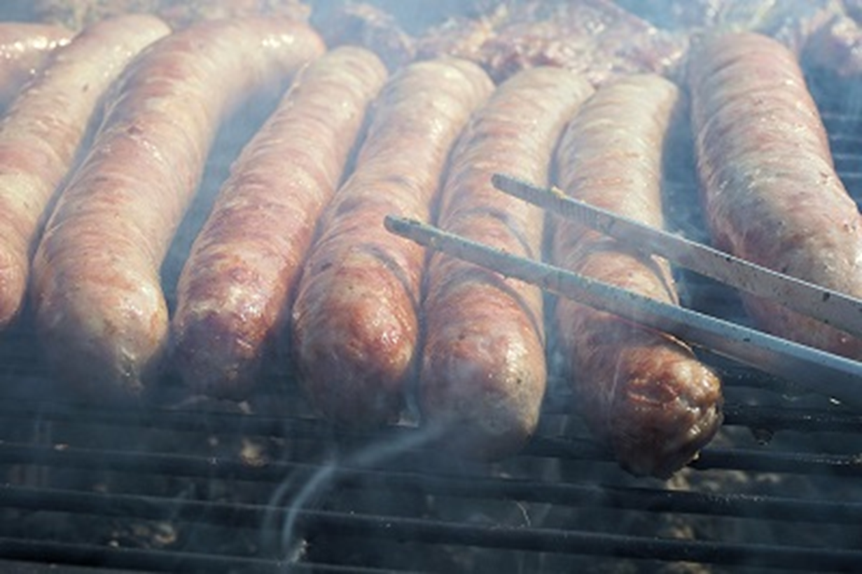 Boudin on the grill with smoke surrounding it