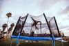 a person flipping on a tramp while others watch them perform